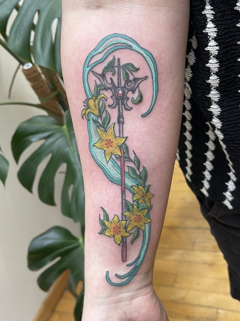 a tattoo of Aerith's staff from Final Fantasy 7 in color with the lifestream behind it